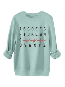 Detail of mint green sweatshirt featuring alphabet print and red heartbeat graphic