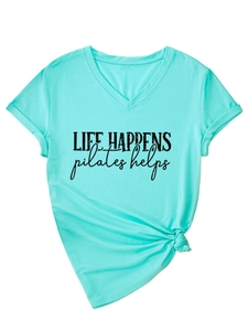 Detail of mint green V-neck T-shirt showing rolled sleeves, front knot, and Pilates slogan