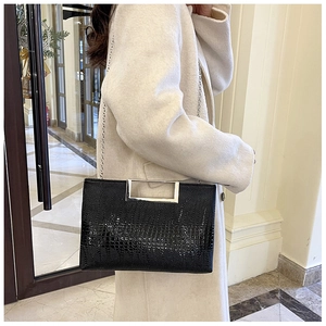 Detail of crocodile pattern leather bag with elegant silver rectangular metal handle