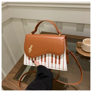 Détail du sac à main rétro avec motif de touches de piano et broderie clé de sol dorée