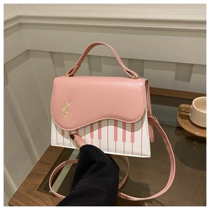 Gros plan détaillé du motif de piano et broderie de note de musique sur sac rose chic
