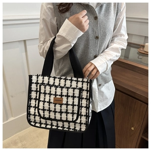 Close-up of black and white checkered tweed tote bag with Jingpin leather label
