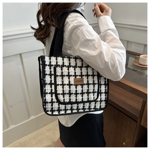 Close-up of black and white plaid tweed tote bag with JINGPIN leather label detail