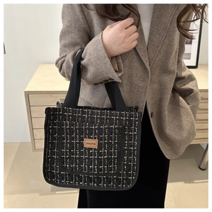 Detail of checkered tweed handbag with JINGPIN leather label and black handles