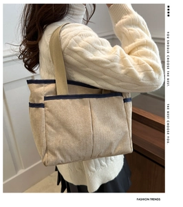 Detail view of beige corduroy tote bag with blue trim and multi-pocket storage design