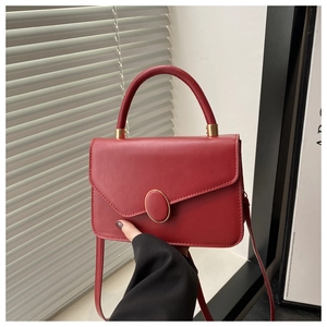 Details der roten strukturierten Handtasche aus Leder mit goldenem Drehverschluss