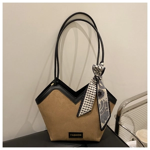 Detail of suede tote bag with geometric scarf and fashion label on black surface
