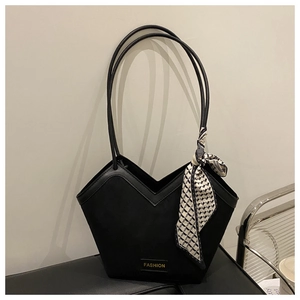 Detail of black tote bag with geometric V-shaped opening and decorative silk scarf accessory