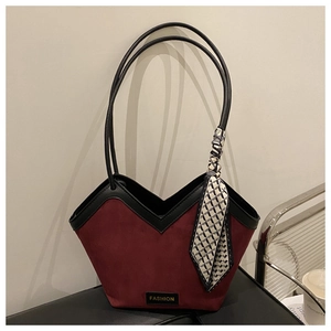 Detail view of burgundy suede tote bag featuring black trim and decorative silk scarf