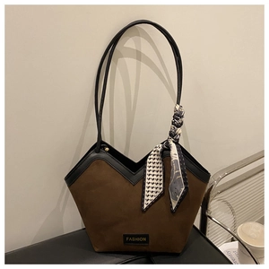 Detail view of large brown suede tote bag with black leather trim and silk scarf accent