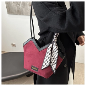Close-up of burgundy suede tote bag with V-shaped cut and silk scarf handle detail