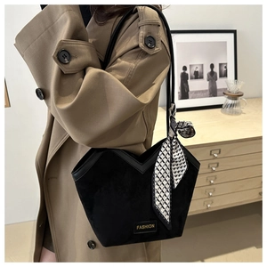 Detail of black matte tote bag with V-shaped cut, fashion logo and geometric silk scarf