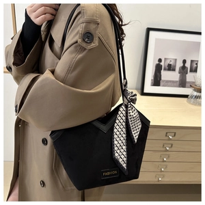 Close-up of black suede tote bag with silk scarf detail and FASHION brand label