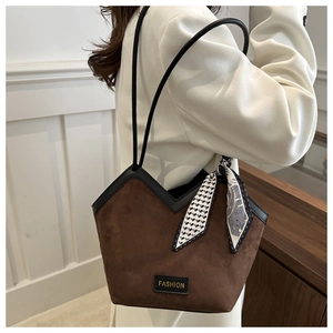 Detail of dark brown suede tote bag with silk scarf and fashion tag on shoulder strap