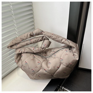 Detail of quilted floral dumpling bag with 'Beautiful' print and knotted handle design