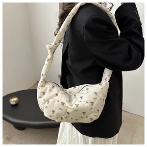 Détail du sac hobo matelassé crème avec imprimé floral rouge et bandoulière nouée