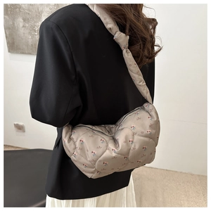 Détail du sac bandoulière matelassé à fleurs avec large bandoulière en couleur gris-vert