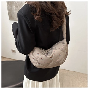 Détail du sac hobo avec matelassage floral et matériau en nylon taupe raffiné