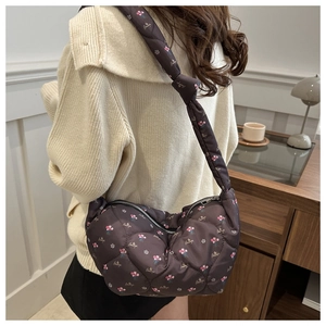 Détail du sac matelassé marron foncé avec motifs floraux et bandoulière à nœud décoratif