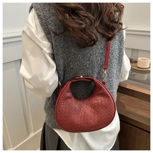 Model wearing a red woven crescent bag showing detail of textured cross-weave pattern