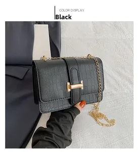 Detail showing black crocodile texture crossbody bag with gold metal H buckle and chain