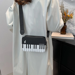 Crossbody bag with piano keys and musical notes design featuring a wide shoulder strap