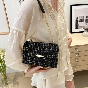 Elegant black and white tweed crossbody bag with golden clasp and chain strap