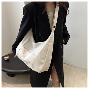 Detail of adjustable wide strap and smooth nylon fabric on beige minimalist tote bag