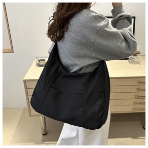 Side view of large black waterproof nylon tote bag showing spacious capacity and wide strap
