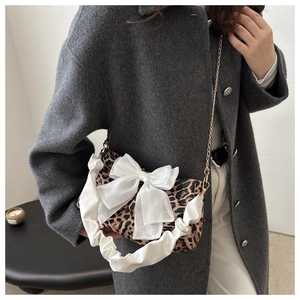 Dettaglio borsa leopardata con grande fiocco in chiffon bianco e catena dorata sottile