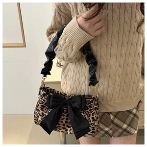 Detail of leopard print handbag with large black bow and ruched shoulder strap