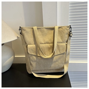 Dettaglio della borsa tote in velluto a coste beige con texture a costine e tasca