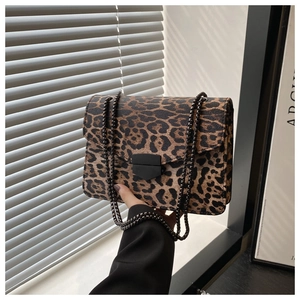 Détail du sac léopard avec chaîne en métal noir mat et boucle de fermeture chic