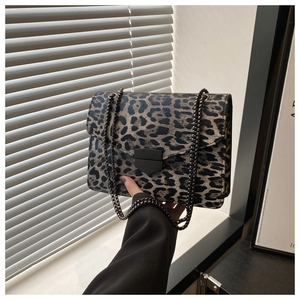 Détail du sac léopard avec boucle noire mate et bandoulière en chaîne métallique