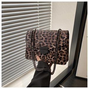 Détail du sac léopard avec bandoulière chaîne noire et fermoir métallique