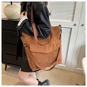 Close-up of caramel corduroy tote bag showing textured fabric and front pocket detail