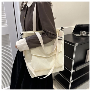 Off-white corduroy tote bag with large front pocket and adjustable strap for women