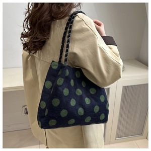 Detailed texture of polka dot tote bag with woven handles and warm wool-like fabric