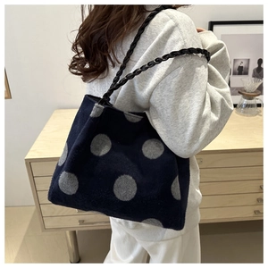 Shoulder bag in navy plush fabric with grey polka dots and woven black leather strap