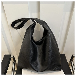 Detailed close-up of textured black PU leather and spacious design on a tote bag