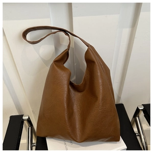 Detail shot of caramel brown faux leather tote bag with soft vintage pleated texture