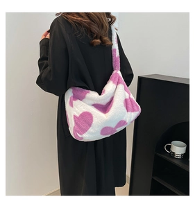 Detailansicht einer weißen Plüschtasche mit lila Herzmuster und Schultergurt von der Seite