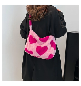 Detail der weichen rosa Plüschtasche mit Herzmuster und breitem Schultergurt aus Kunstpelz