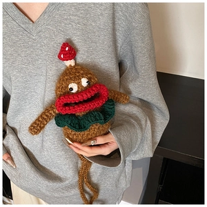 Detail of handmade knit monster bag with big red lips and polka dot mushroom