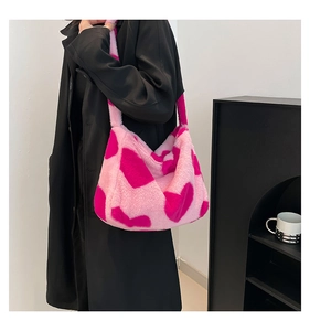 Detailierte Textur der pinken Plüschtasche mit fuchsia Herzmuster auf schwarzem Mantel
