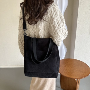 Borsa tote classica in velluto a coste nero con tracolla e tasca frontale sul modello