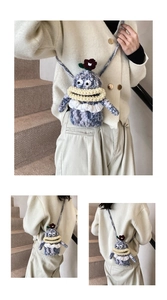 Close-up of handmade purple knitted monster crossbody bag with big eyes and yellow lips