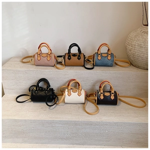 Mini borse Boston in rosa, marrone, denim e pelle nera su gradini di pietra