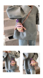 Detailed macro view of handmade crochet monster mini bag with 3D eyes and floral accents