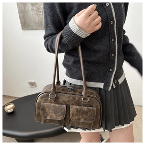 Dettaglio della borsa bowling vintage marrone con tasche frontali e texture opaca
